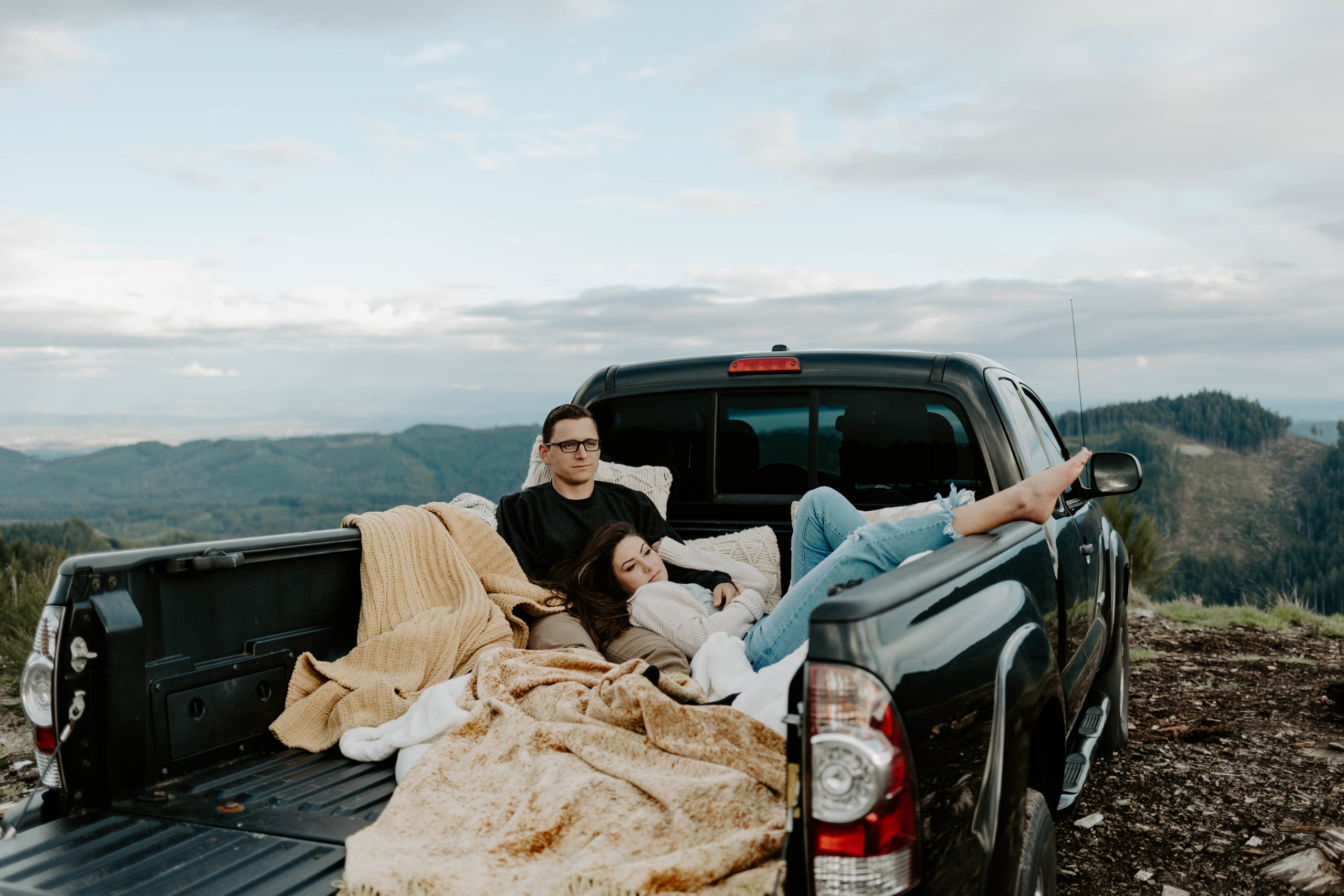 Couple laying in truck bed outdoors